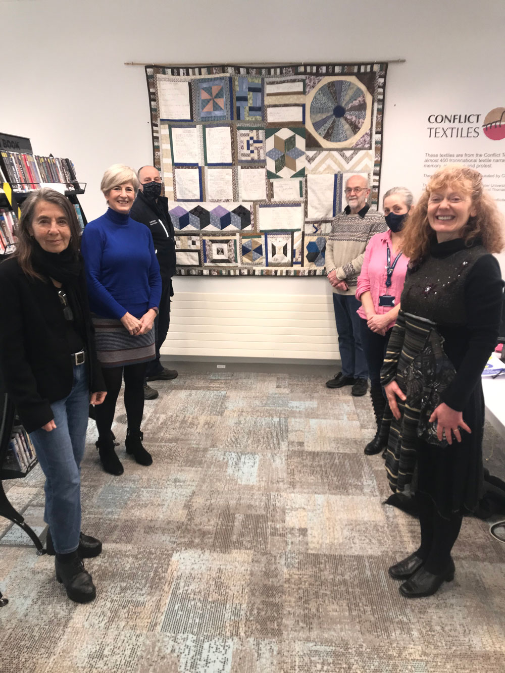 Conflict Textiles Team and Magee Campus Library and Estates staff pictured at the installation of the quilt 